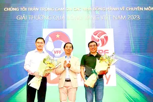 Nhà báo Nguyễn Nhật, Trưởng Ban Tổ chức giải thưởng, tặng hoa đại diện nhà đồng hành về chuyên môn - VFF và FPT Play. Ảnh: DŨNG PHƯƠNG