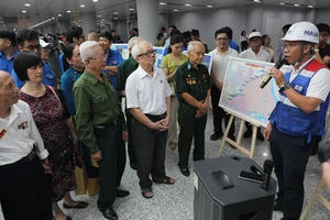 Nhân viên Ban Quản lý đường sắt đô thị TPHCM giới thiệu dự án metro số 1 đến các cựu binh Điện Biên Phủ và đại biểu tham gia buổi chạy thử nghiệm metro. Ảnh: DŨNG PHƯƠNG