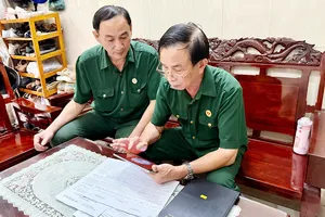 Ông Nguyễn Ngọc Thám, người cựu chiến binh với vai trò Bí thư Chi bộ khu phố 20 phường Minh Phụng (bên phải), thuần thục với các thao tác trên phần mềm điện tử. Ảnh: CẨM NƯƠNG