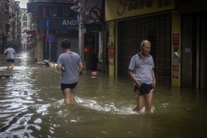 9 月 24 日的台风袭击中国澳门特别行政区，行人穿过被洪水淹没的街道。