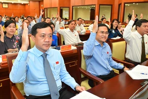 Các đại biểu HĐND TPHCM biểu quyết thông qua nghị quyết kỳ họp. Ảnh: VIỆT DŨNG