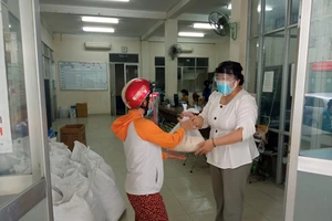 Ngoài 1,5 triệu đồng, mỗi người còn nhận được 5kg gạo từ đóng góp của các nhà hảo tâm. Ảnh: MAI HOA