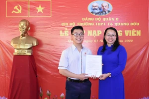 Trưởng Ban Tổ chức Quận ủy quận 8 Nguyễn Thị Ngọc Hà trao quyết định kết nạp đảng viên mới cho quần chúng ưu tú Nguyễn Ngọc Quang Hà, học sinh lớp 12A12 Trường THPT Tạ Quang Bửu