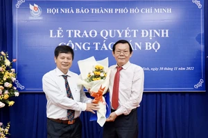 Nhà báo Trần Trọng Dũng trao hoa và quyết định cho nhà báo Nguyễn Tấn Phong. Ảnh: HOÀNG HÙNG 