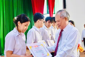 Ông Lương Đức Đích, Phó Chủ tịch Thường trực Hội Khuyến học TPHCM trao học bổng cho các em học sinh, sinh viên.
