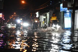 Triều cường dâng cao, người dân bì bõm lội nước về nhà