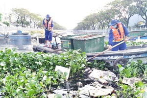 Công nhân Công ty Môi trường đô thị TPHCM vớt rác trên tuyến kênh Tân Hóa - Lò Gốm. Ảnh minh họa