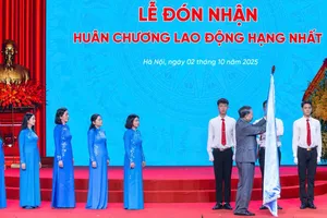 Tổng Bí thư Tô Lâm gắn Huân chương Lao động hạng nhất lên lá cờ truyền thống của Hội LHPN Việt Nam. Ảnh: VIẾT CHUNG
