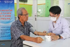 Nhân viên y tế đo huyết áp cho người cao tuổi