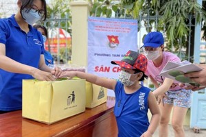 共青團團員指引兒童分類垃圾。