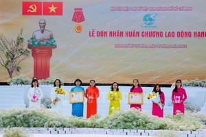 杜氏秋草與阮氏麗同志向市婦聯會所屬單位頒授三等勞動勛章。