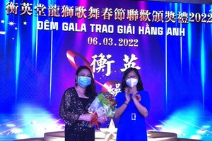 　　市委民運處民族宗教部副主任郭氏蓮二 (右)向歌手秀玲頒獎。