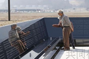 　　一對夫婦正在遇難者紀念碑前確認親友的名字。圖源：互聯網