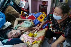 　　徐氏節梅正照顧癱瘓在床的丈夫王溫昌。