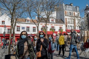 法國巴黎民眾外出時佩戴口罩。