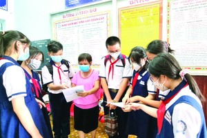 文朗學校初中考生考完試後向老師匯報考試情況。