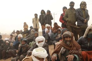 在阿富汗赫拉特省的一個偏遠地區，人們在等待分發食物。