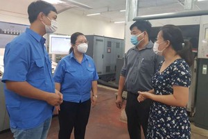第七印刷股份公司黨委書記黎氏碧幸（右一）與公司的黨員交流。