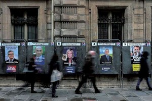 4月7日，人們從法國總統大選廣告牌前走過。