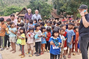 梁肇添、鄭成龍（後排左一、二）和梁志偉（前排右一）向小朋友發送禮物後留影。