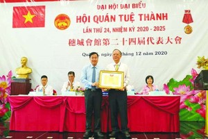 第五郡越南祖國陣線委員會主席向穗城會館理事長盧耀南頒發獎狀。