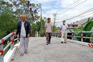 武文祿大伯（左一）在他自己與其他成員募捐經費修建的橋樑。