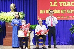 市人民議會主席阮氏麗向黨員頒授黨齡紀念章。