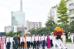 市領導代表團在第一郡阮惠街胡志明主席塑像公園敬獻花籃。