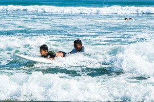 某小朋友在廣南省會安市安龐海上戴著浮袖學習衝浪。