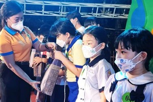 第五郡勞動聯團主席黎氏碧幸向職工的 子弟贈送禮物。