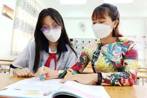 第一郡黃康寧初中學校教師范氏清水與學生。