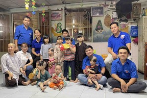 越南畜產技藝股份公司（Vissan）共青團書記陳青科（左站者）前往 第十二郡溫情屋探望不幸兒童。