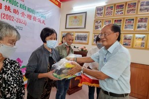 溫陵會館理事長洪世真發禮物和輔助金給貧困高齡福建鄉親。