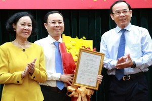 中央組織部長張氏梅與市委書記阮文年祝賀阮文孝同志（中）出任新任務。