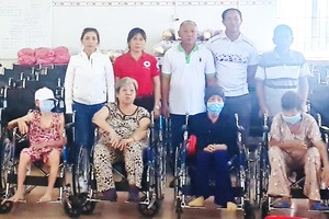 理事長鄭成龍(後排左三)等向殘疾人士 贈送輪椅。