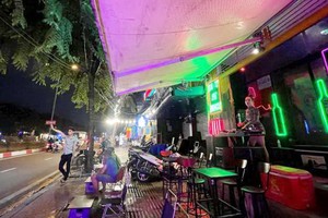 舊邑郡范文同街某酒肆的女DJ調高播放音量，而工作人員在 街上拉攏顧客。