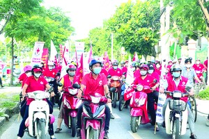 第八郡紅十字會幹部、志願者騎著 摩托車去宣傳。