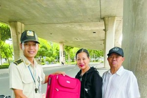 保安員梅國慶(右一)把行李箱交回失主。