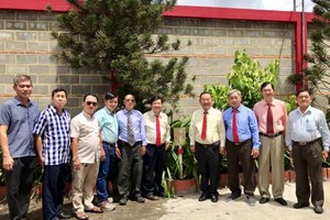 崇正慈善會館理事在觀音閣栽種松樹。