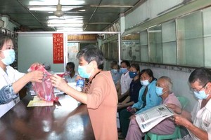 林麗水主席正為烈士家屬派發藥品。