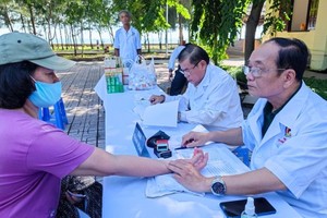 退伍軍人莊鴻州（右）為芹耶縣芹盛市鎮窮人診病。