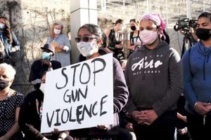 2021年，人們手舉“停止槍枝暴力”的標語在參加槍擊案受害者悼念儀式。圖源：互聯網