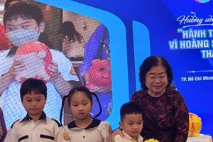 原國家副主席張美華(右一)接收小學生捐贈“土豬”。