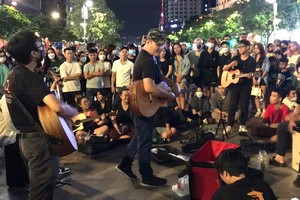 觀眾在阮惠步行街與樂隊進行文化交流。