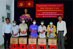 本報編委文忠孝(左一)與第八郡郡紅十字輔助會副會長陳健安(右一)向華人貧困戶轉送盂蘭節禮物。