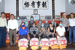 義安會館理事長陳裕、副理事長鄭學才向貧困者派發盂蘭賑濟品。