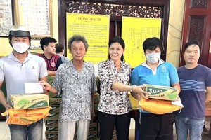 沙瀝市祖國陣線委員會副主席阮氏嫻 (左三)和林長江忠盛(左二)等派發禮物予窮人。