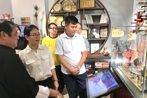 黃志民師傅（左一）向第十一郡領導介紹“傳承閣”。