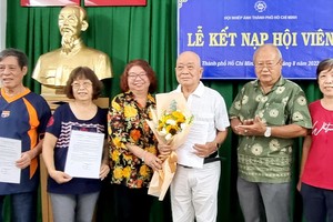 市各民族文學藝術協會常值副主席張四妹(左三)前來祝賀獲接納會員的華人攝影家。