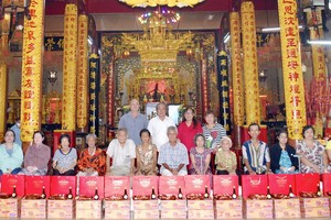 　　海南會館常值副理事長孫盛強(後排左二)和各理事成員向諸位孤寡鄉親派發禮物。